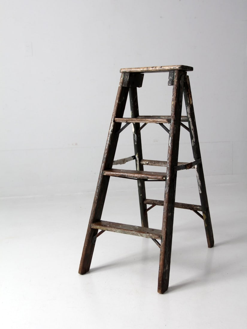 Charming Vintage Green Wood Painter's Ladder Decorative A-Frame: Charming Vintage Green Wood Painter's Ladder Decorative A-Frame This vintage wooden painter's ladder showcases a charming green A-frame design, complete with three sturdy rails and metal hinges. Adorn