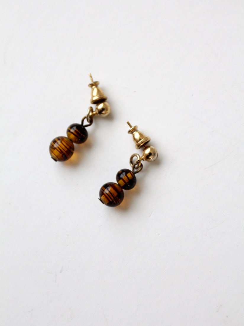 Vintage Topaz Art Glass Drop Earrings with Golden Studs: Vintage Topaz Art Glass Drop Earrings with Golden Studs Illuminate your style with these Vintage Topaz Art Glass Drop Earrings. Crafted from exquisite topaz tone art glass, these earrings showcase rad