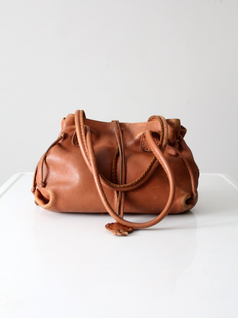 Carlos Falchi Vintage Brown Leather Hobo Bag with Braided Detail: Carlos Falchi Vintage Brown Leather Hobo Bag with Braided Detail Discover this exquisite vintage shoulder bag by Carlos Falchi, showcasing a timeless hobo style crafted from rich brown leather. This h