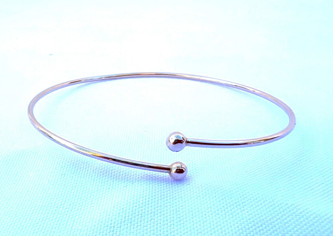 Tiffany & Co 14K Yellow Gold Flexible Bangle Bracelet: Tiffany & Co 14K Yellow Gold Flexible Bangle Bracelet This exquisite Tiffany & Co. 14K yellow gold bangle bracelet is a perfect blend of elegance and craftsmanship. Designed in a classic bangle style,