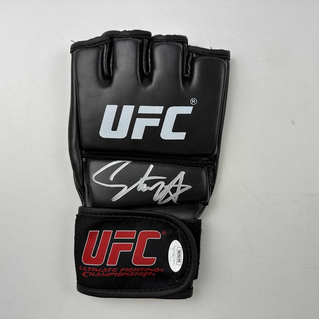 Autographed Israel Adesanya UFC MMA Glove with JSA COA: Autographed Israel Adesanya UFC MMA Glove with JSA COA This authentic black UFC MMA glove is autographed by Israel Adesanya, a prominent fighter in the UFC. The signature is verified by James Spence A