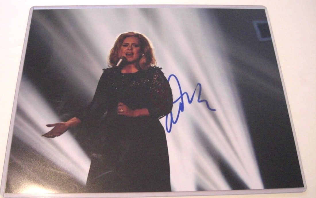 Adele Signed 11x14 Photo Grammy Winner Autograph: Adele Signed 11x14 Photo Grammy Winner Autograph This is an authentic 11x14 photograph signed by Grammy Award-winning singer Adele. The photo showcases her in a stunning pose, making it a perfect coll
