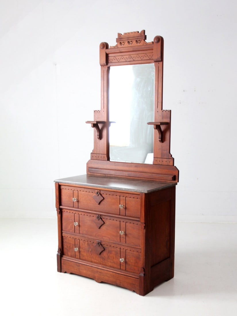 Victorian Eastlake Antique Dresser with Grand Mirror: Victorian Eastlake Antique Dresser with Grand Mirror This exquisite antique Victorian Eastlake style dresser features intricate carvings and a spacious marble top, complemented by a grand attached mir