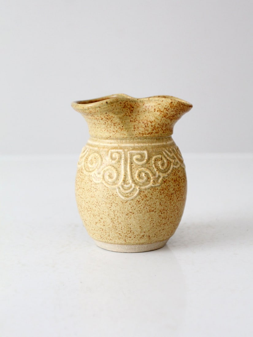 Vintage Mustard Studio Pottery Vase with Geometric Pattern: Vintage Mustard Studio Pottery Vase with Geometric Pattern This vintage studio pottery vase showcases a warm mustard tone complemented by a speckled glaze finish. A raised, swirling geometric pattern