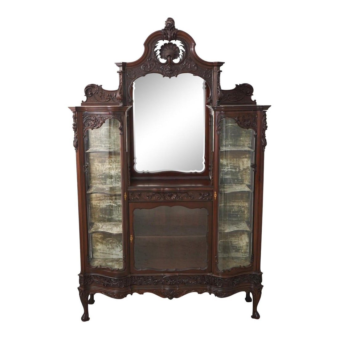 Victorian Antique Mahogany Curio Cabinet with Serpentine Glass Doors: Victorian Antique Mahogany Curio Cabinet with Serpentine Glass Doors This Antique Victorian Curio Display Cabinet, dating from 1880 to 1900, features exquisite carved details and high-quality construc