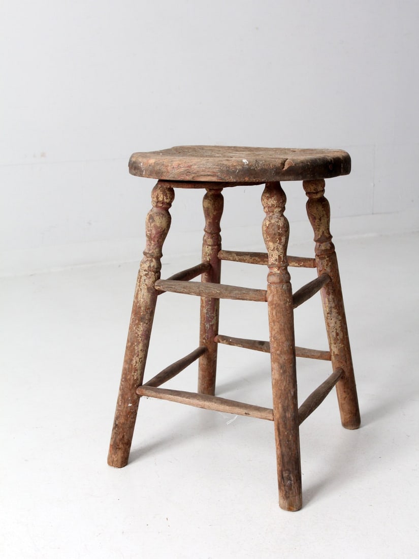 Vintage Rustic Wood Farmhouse Stool with Cream Paint: Vintage Rustic Wood Farmhouse Stool with Cream Paint Embrace rustic charm with this antique wooden farmhouse stool, featuring beautifully turned legs and subtle traces of cream paint. The round wood s