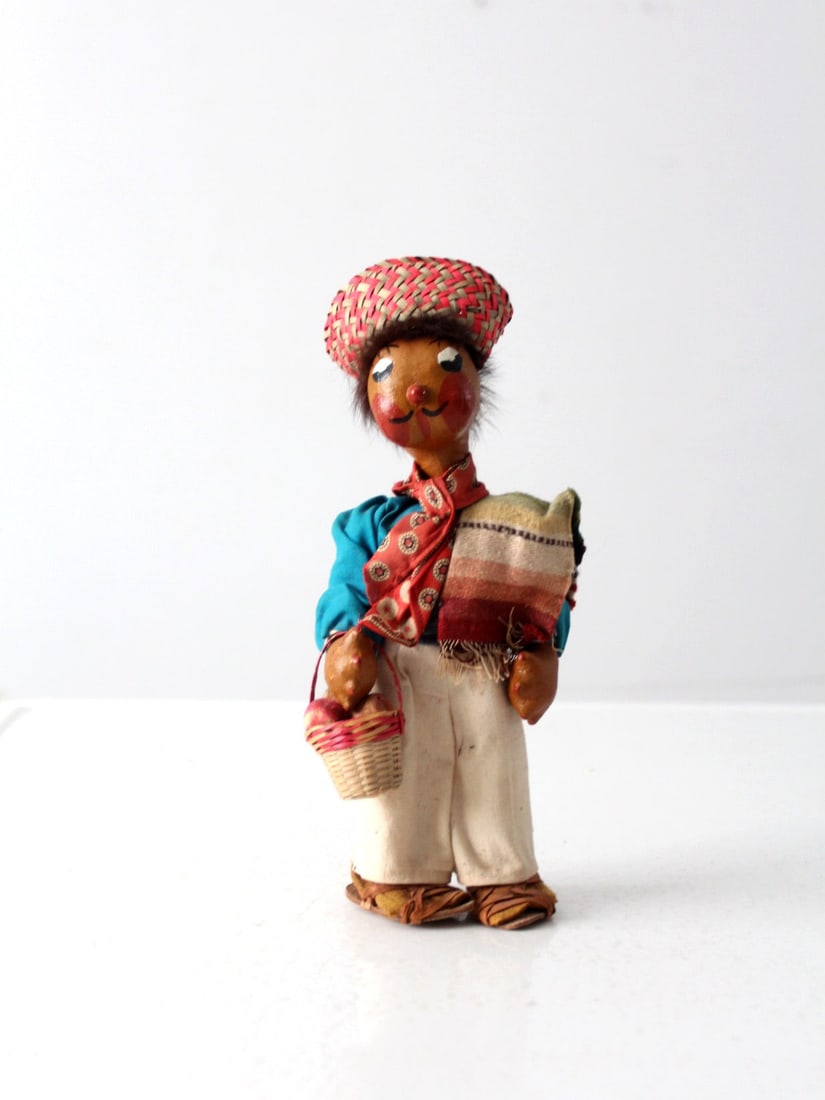 Vintage 1940s Mexican Folk Art Oil Cloth Doll with Basket: Vintage 1940s Mexican Folk Art Oil Cloth Doll with Basket This charming hand-crafted Mexican folk art oil cloth doll from the 1940s showcases traditional attire, complete with a woven hat and a basket