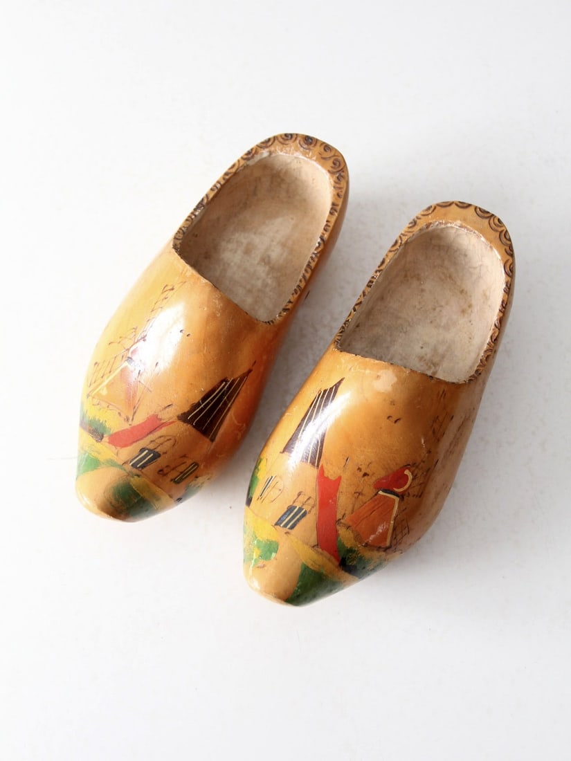 Charming Vintage Dutch Clogs with Hand-Painted Landscape: Charming Vintage Dutch Clogs with Hand-Painted Landscape This exquisite pair of vintage Dutch clogs (klompen) features intricate carved swirls and hand-painted scenes depicting a classic Dutch landsca