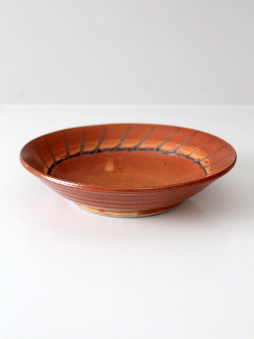 Signed Vintage Studio Pottery Bowl with Terra-Cotta Glaze: Signed Vintage Studio Pottery Bowl with Terra-Cotta Glaze This vintage studio pottery bowl showcases a beautiful warm terra-cotta orange glaze, elegantly accented by subtle black etched stripes around