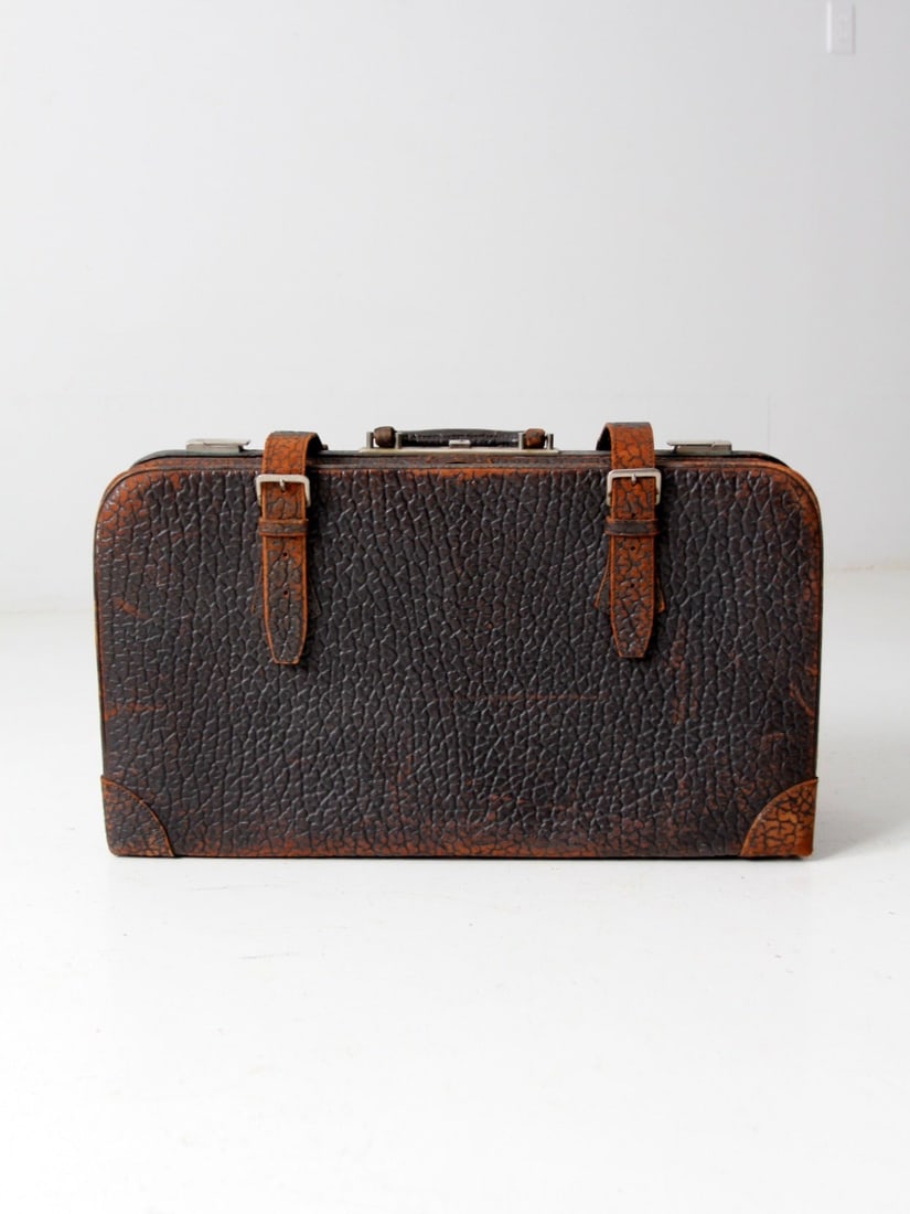Vintage 1930s Brown Leather Suitcase with Plaid Interior: Vintage 1930s Brown Leather Suitcase with Plaid Interior This vintage 1930s textured leather suitcase showcases a striking graphic presence with its deep brown surface and rounded corners, complemente