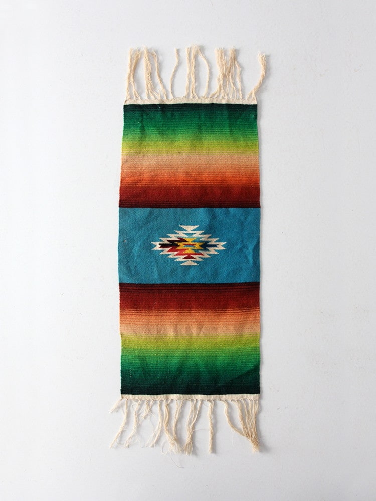 Vintage Wool Mexican Serape Table Runner with Fringe: Vintage Wool Mexican Serape Table Runner with Fringe Enhance your decor with this Vintage Mexican Serape Style Table Runner. Crafted from finely woven wool, this mat showcases a vibrant pattern featur