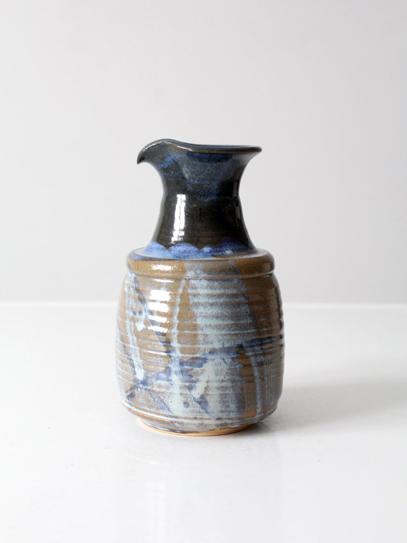 Vintage Studio Pottery Carafe Blue Brown Glaze Decorative Accent: Vintage Studio Pottery Carafe Blue Brown Glaze Decorative Accent This vintage studio pottery pitcher showcases a beautiful fluid blue and brown glaze, elegantly crafted into a spouted form. It serves