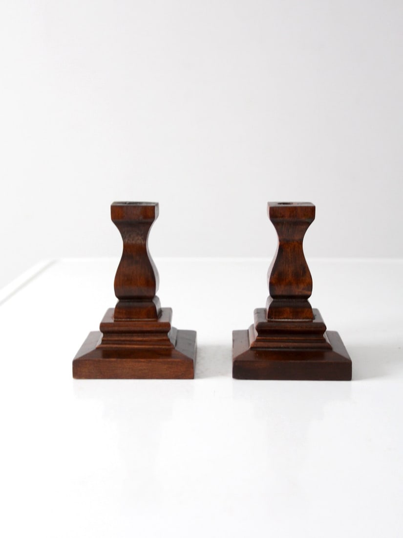 Pair of Vintage Handmade Wooden Candlestick Holders: Pair of Vintage Handmade Wooden Candlestick Holders This pair of vintage handmade wooden candlestick holders showcases a unique sculpted silhouette that rises from stepped square bases. The elegant da