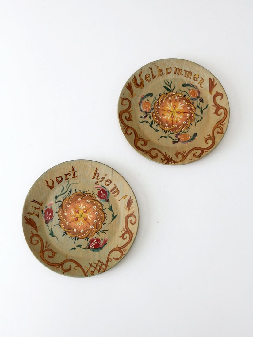 1958 Norwegian Hand-Painted Wooden Plates Pair with Floral Design: 1958 Norwegian Hand-Painted Wooden Plates Pair with Floral Design This charming pair of hand-painted Norwegian plates, dated 1958, showcases exquisite floral designs. One plate features the word "Velk