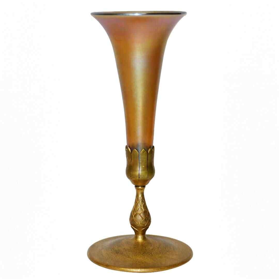 Tiffany Studios Favrile Glass Trumpet Vase Gold on Bronze Base: Tiffany Studios Favrile Glass Trumpet Vase Gold on Bronze Base This exquisite medium-sized table vase features a stunning design from Tiffany Studios, showcasing the iconic Favrile glass in a beautifu