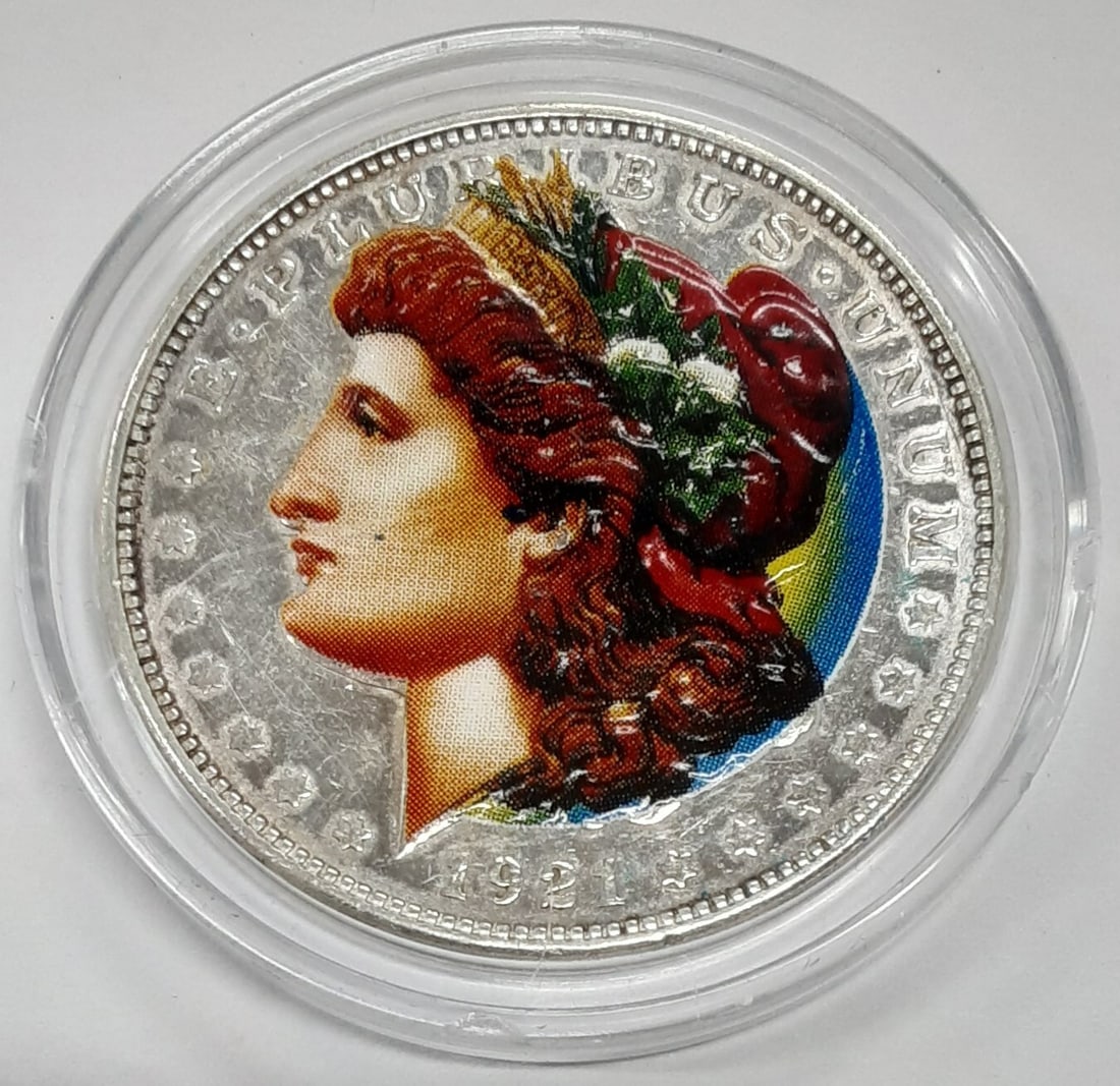 1921-D Morgan Silver Dollar Colorized Liberty in Case: 1921-D Morgan Silver Dollar Colorized Liberty in Case This 1921-D Morgan Silver Dollar features a stunning colorized depiction of Liberty. The coin is made of silver and has a fineness of 0.9. It was
