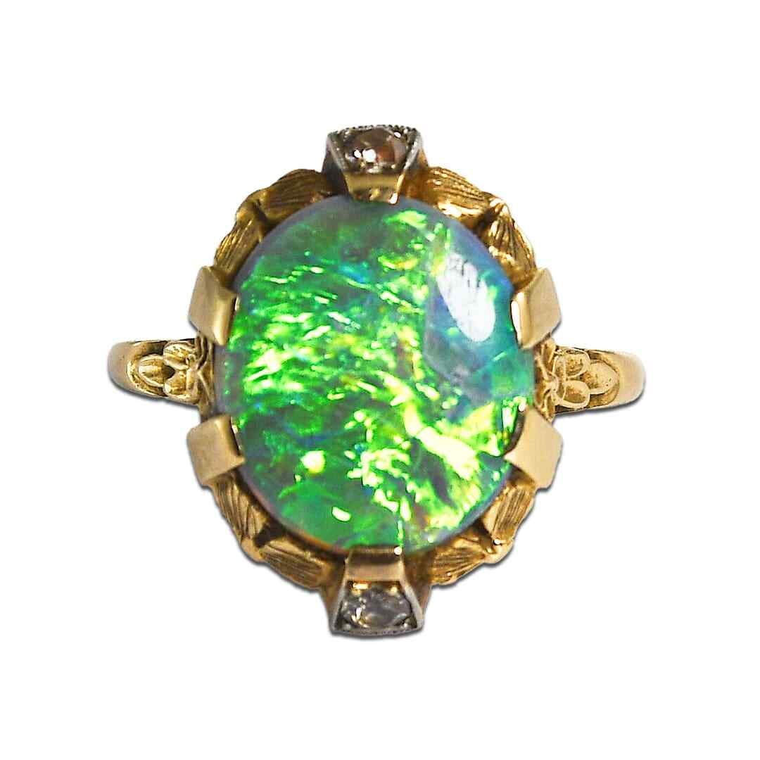 Vintage 14K Yellow Gold Black Opal Diamond Cocktail Ring: Vintage 14K Yellow Gold Black Opal Diamond Cocktail Ring This exquisite vintage cocktail ring showcases a stunning Australian black opal, known for its vibrant green and blue hues. Set in a delicate 1