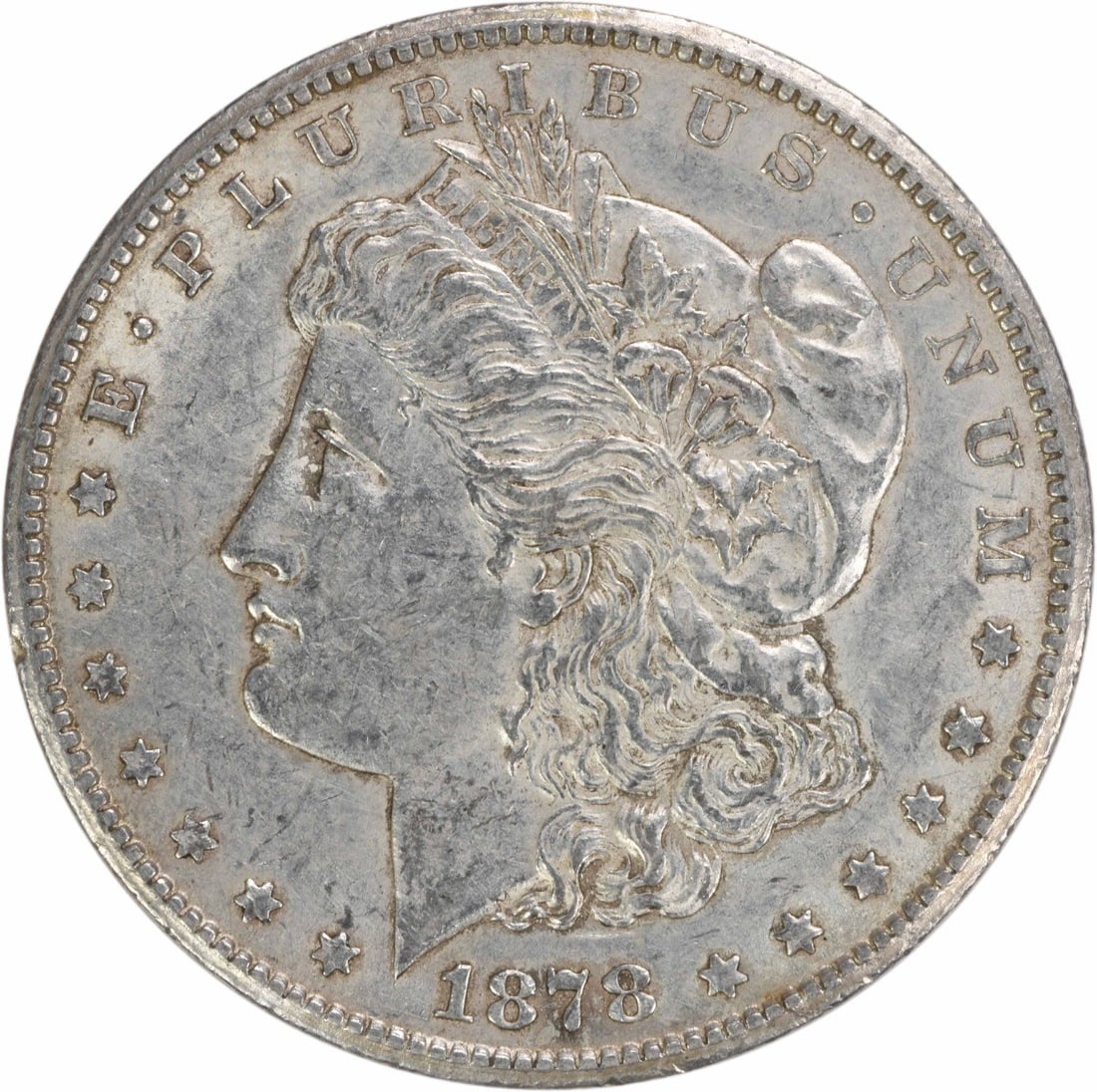 1878-CC Morgan Silver Dollar AU Uncertified 90% Silver Coin: 1878-CC Morgan Silver Dollar AU Uncertified 90% Silver Coin This 1878-CC Morgan Silver Dollar is a remarkable piece of numismatic history, featuring the iconic design by George T. Morgan. Struck at th