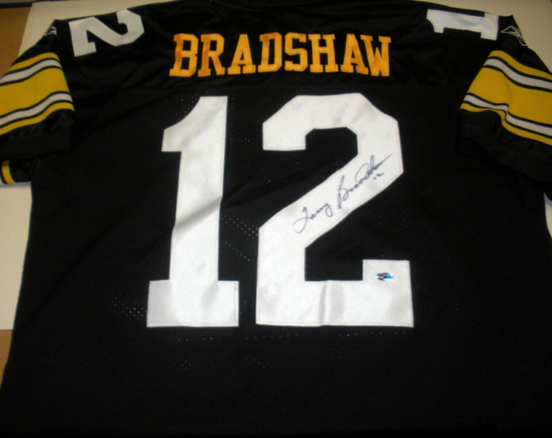 Terry Bradshaw Signed Reebok Jersey Pittsburgh Steelers with COA: Terry Bradshaw Signed Reebok Jersey Pittsburgh Steelers with COA This official licensed Reebok jersey, featuring the legendary Terry Bradshaw of the Pittsburgh Steelers, is a must-have for any