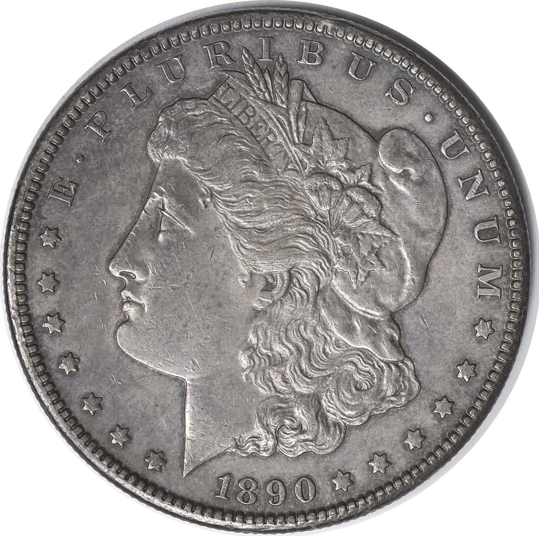 1890-CC Morgan Silver Dollar AU Uncertified 90% Silver Coin: 1890-CC Morgan Silver Dollar AU Uncertified 90% Silver Coin This 1890-CC Morgan Silver Dollar is a remarkable coin from the Carson City mint, showcasing the artistry of designer George T. Morgan. Circ