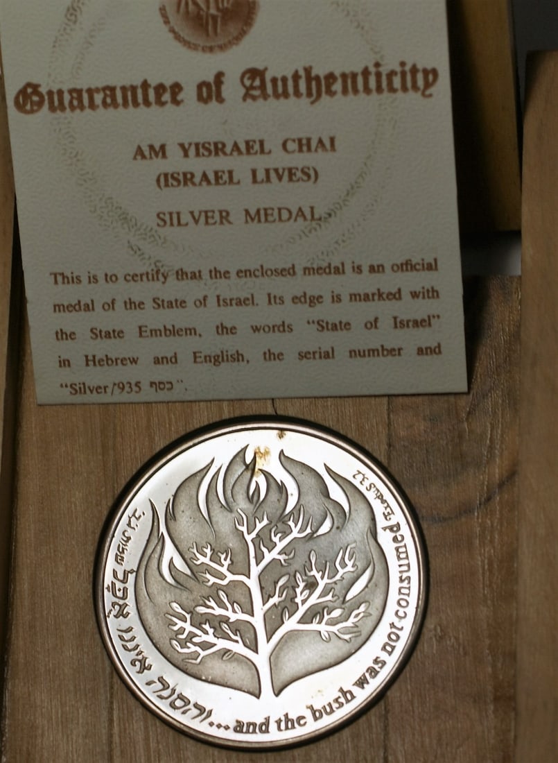 1982 Am Yisrael Chai .935 Silver Proof Medal with COA in Olive Wood: 1982 Am Yisrael Chai .935 Silver Proof Medal with COA in Olive Wood Celebrate the spirit of Israel with this 1982 Am Yisrael Chai .935 Silver State Proof Medal. This exquisite piece is crafted from .9