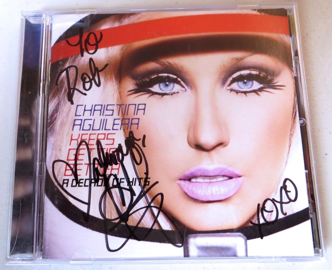 Christina Aguilera Signed Decade of Hits CD Booklet JSA Authenticated: Christina Aguilera Signed Decade of Hits CD Booklet JSA Authenticated This is an authentic autographed CD booklet by Christina Aguilera, featuring her compilation album 'Decade of Hits'. The item has