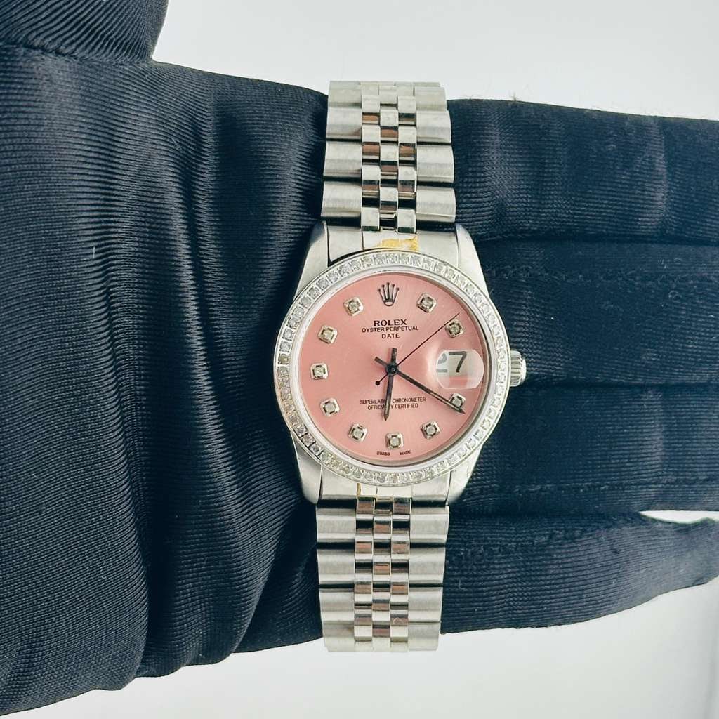 Aftermarket Pink Diamond Dial Oyster Perpetual Date Watch Ref 6694 Jubilee: Aftermarket Pink Diamond Dial Oyster Perpetual Date Watch Ref 6694 Jubilee This Rolex Oyster Perpetual Date features an aftermarket pink diamond dial and a pave diamond bezel, complemented by an after