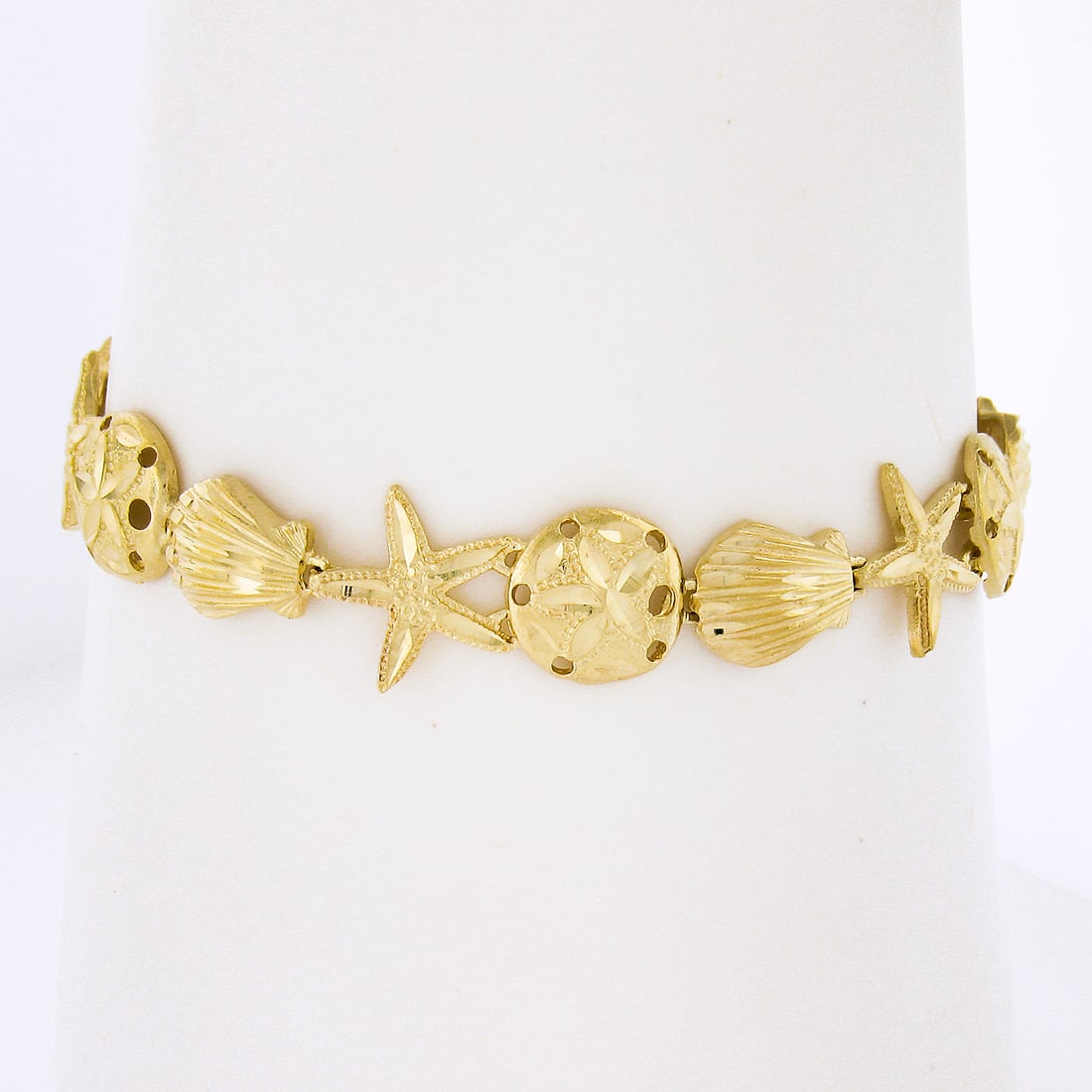 14k Gold 3D Textured Diamond Cut Nautical Link Bracelet: 14k Gold 3D Textured Diamond Cut Nautical Link Bracelet This exquisite 14k Yellow Gold bracelet features a stunning 3D textured design, showcasing a starfish, seashell, and sand star motif, perfect fo