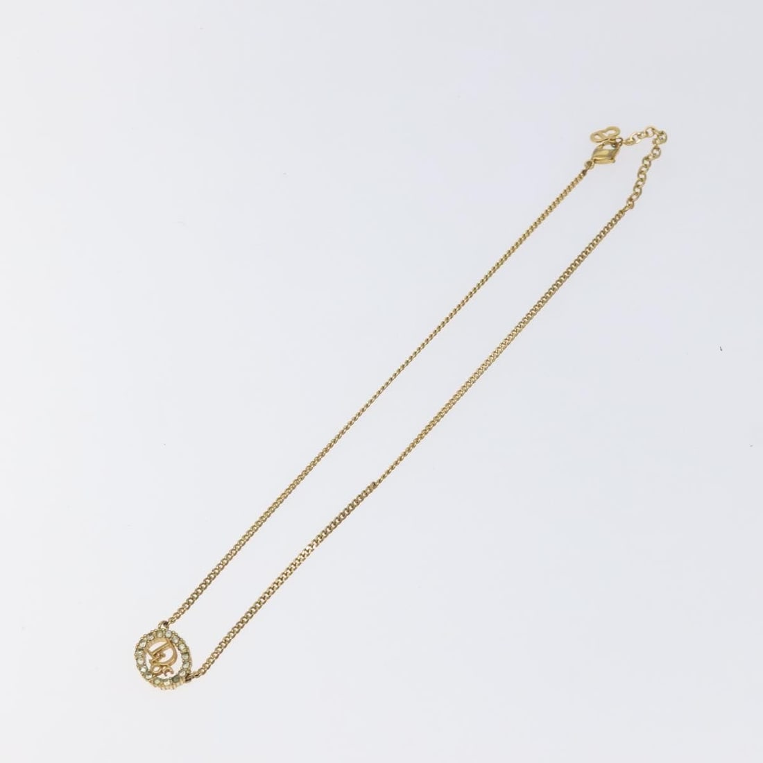 Vintage Christian Dior Gold Tone Logo Pendant Necklace: Vintage Christian Dior Gold Tone Logo Pendant Necklace This Christian Dior vintage round pendant necklace features the iconic logo design in a gold tone. The necklace is designed for women and shows s