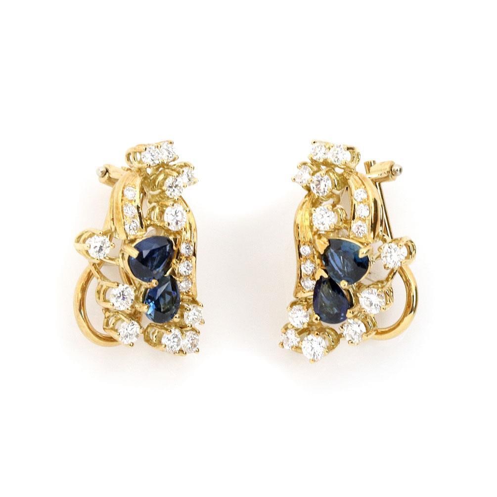 18k Yellow Gold Floral Earrings with Diamonds and Sapphires: 18k Yellow Gold Floral Earrings with Diamonds and Sapphires Adorn your ears with these exquisite 18k yellow gold floral post clip earrings. Meticulously crafted, each earring showcases a stunning flor