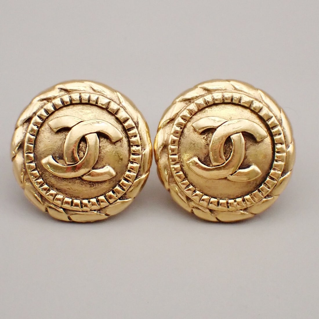 Vintage Chanel Gold Tone CC Logo Clip-On Earrings: Vintage Chanel Gold Tone CC Logo Clip-On Earrings These Chanel vintage CC round clip-on earrings feature the iconic interlocking CC design in a gold tone. Designed for women, they are in good conditio