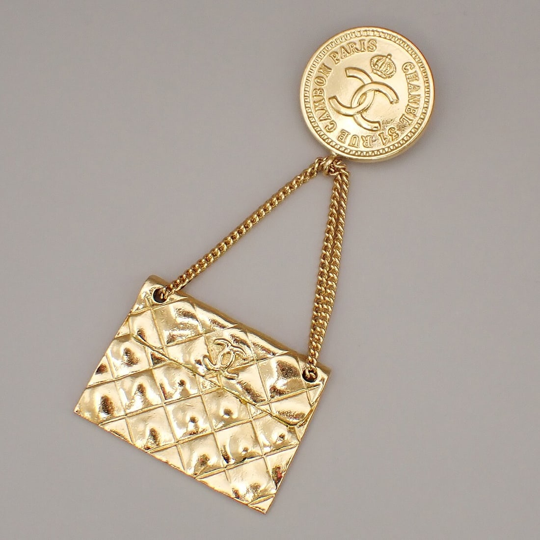 Chanel Vintage Gold Tone Medallion Flap Bag Brooch: Chanel Vintage Gold Tone Medallion Flap Bag Brooch This Chanel Vintage Medallion Flap Bag brooch features a gold tone finish and is designed for women. The brooch is in excellent condition with visibl