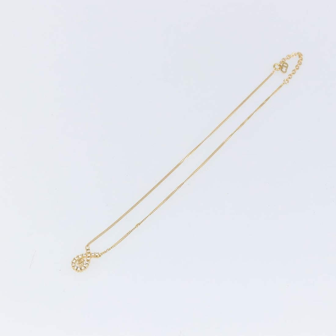 Gold Pendant Necklace by Christian Dior with CD Logo: Gold Pendant Necklace by Christian Dior with CD Logo This pre-owned Christian Dior pendant necklace features a gold-tone finish and a CD pendant design. The necklace is in very good condition with min