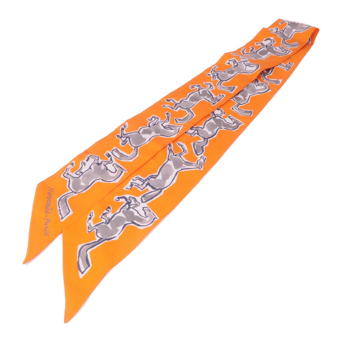 HERMES Twilly Scarf Silk Orange France: HERMES Twilly Scarf Silk Orange France Elevate your accessory collection with this stunning HERMES Twilly Scarf, crafted from luxurious silk. The vibrant orange color adds a pop of brightness to any o