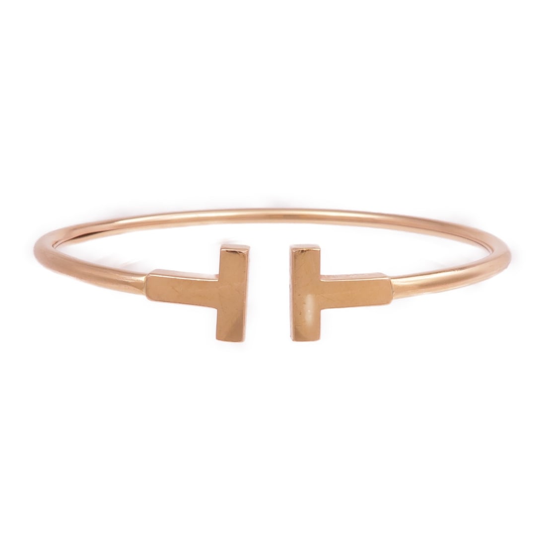 18K Rose Gold T Wire Bracelet by Tiffany and Co: 18K Rose Gold T Wire Bracelet by Tiffany and Co This Tiffany & Co. T Wire bracelet is crafted in 18K pink (rose) gold and features a minimalist, elegant design without any gemstones. It is a regular s
