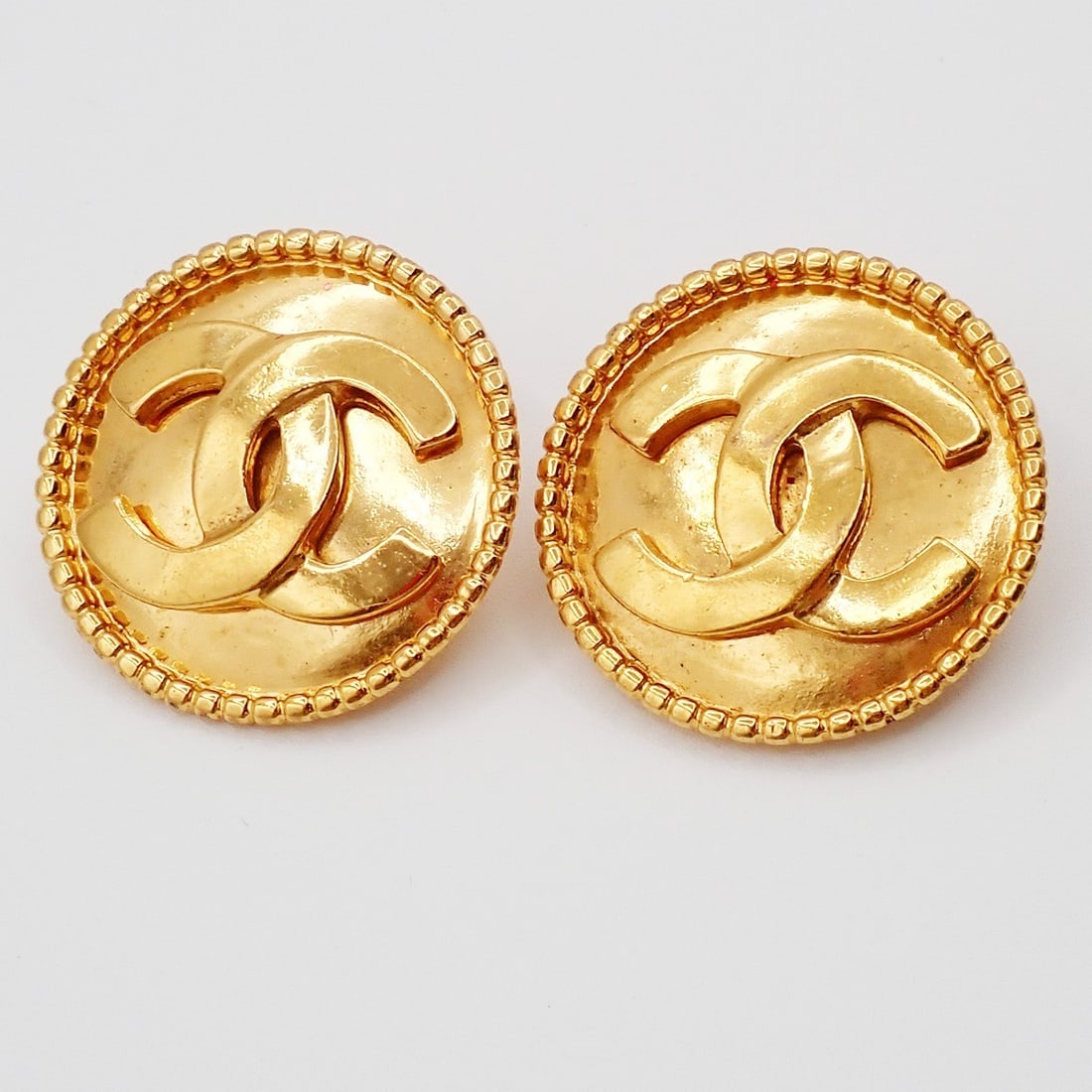 Vintage Chanel Clip-On Earrings with Round CC Logo Gold Tone: Vintage Chanel Clip-On Earrings with Round CC Logo Gold Tone These Chanel vintage round CC clip-on earrings feature a classic design and are crafted in a gold tone. They are in good condition, display