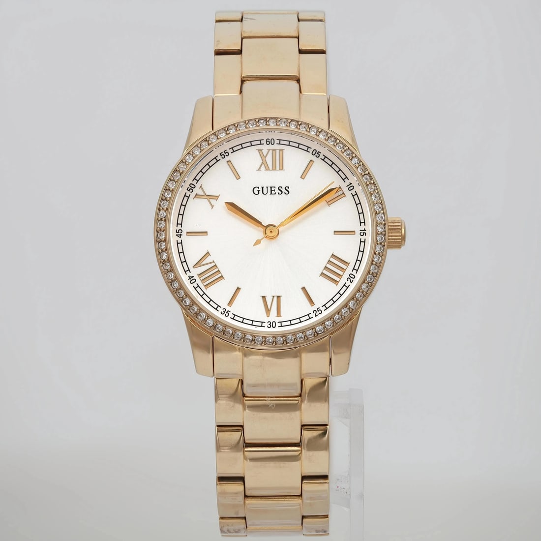 GUESS Status 32mm Gold-Tone Quartz Watch with Silver Sunburst Dial: GUESS Status 32mm Gold-Tone Quartz Watch with Silver Sunburst Dial Discover the elegance of the Guess Status wristwatch, a perfect blend of style and functionality. This casual watch features a stunni