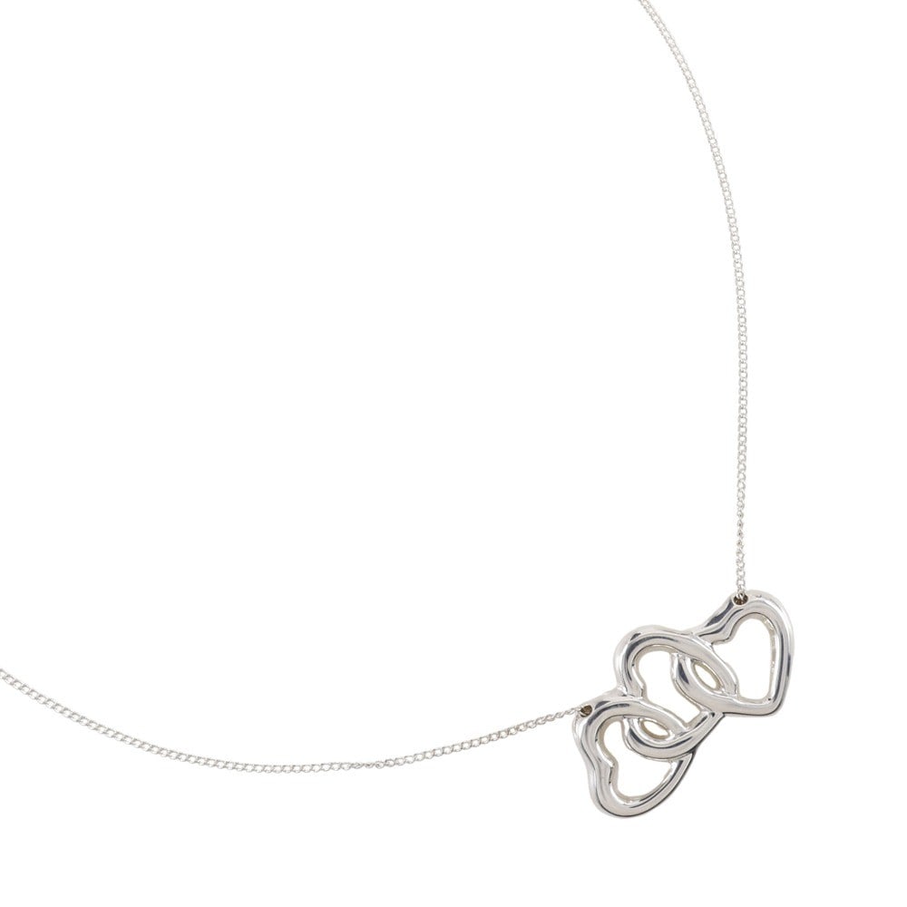 Triple Heart Silver Necklace by Tiffany & Co.: Triple Heart Silver Necklace by Tiffany & Co. This Tiffany & Co. triple heart pendant necklace features a polished silver finish. The necklace is designed for female wearers and remains in pristine, u