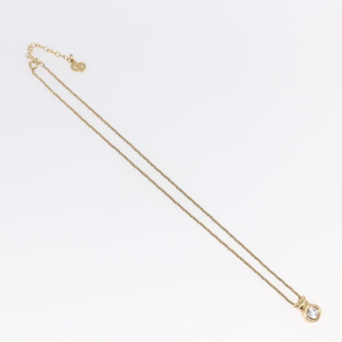 Gold Pendant Necklace with CD Logo by Christian Dior: Gold Pendant Necklace with CD Logo by Christian Dior This pre-owned Christian Dior necklace features a gold-tone CD pendant. It is in good condition with minor surface scratches and a noticeable metal