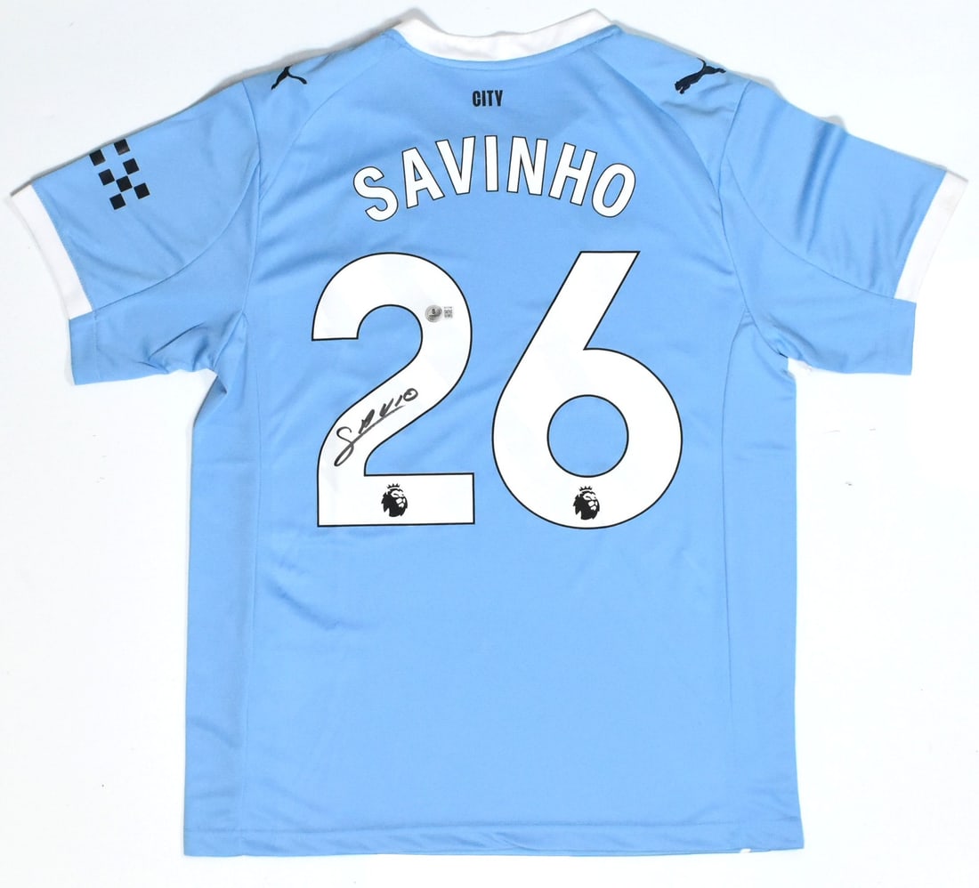 Savinho Autographed Manchester City Home Jersey #26 Beckett Holo: Savinho Autographed Manchester City Home Jersey #26 Beckett Holo This is an original autographed Manchester City home soccer jersey featuring the signature of player Savinho, designated as #26. The je