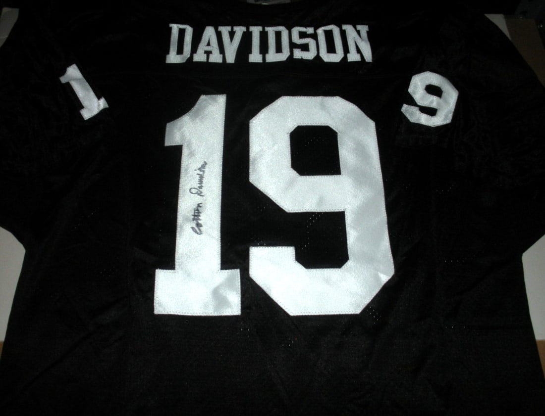 COTTON WILSON OAKLAND RAIDERS JERSEY WITH COA: COTTON WILSON OAKLAND RAIDERS JERSEY WITH COA This officially licensed Wilson jersey is a rare find for Dallas Texans fans. Crafted from high-quality cotton, this pre-owned jersey features a signed ce