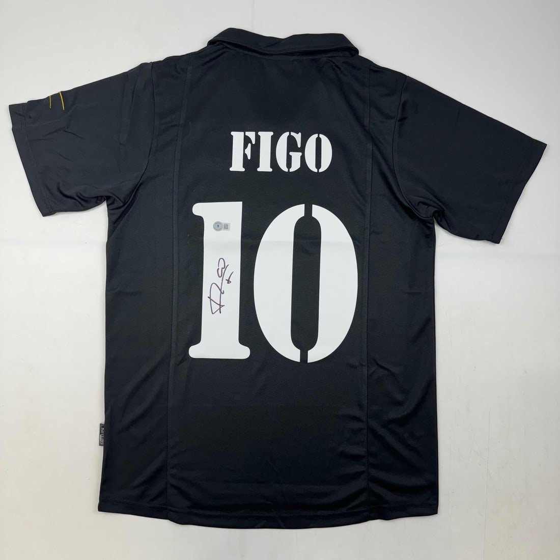 Luis Figo Autographed Real Madrid Black Soccer Jersey Beckett COA: Luis Figo Autographed Real Madrid Black Soccer Jersey Beckett COA This is an authentic, autographed black soccer jersey of Luis Figo, featuring the Real Madrid team. The jersey is custom-made and does