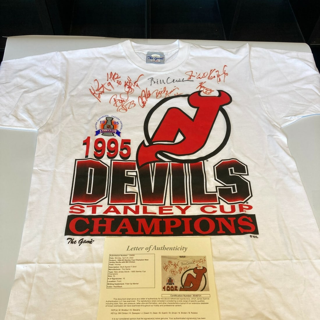1995 New Jersey Devils Signed Shirt with Bill Clinton JSA Authenticated: 1995 New Jersey Devils Signed Shirt with Bill Clinton JSA Authenticated Celebrate the historic achievement of the 1995 New Jersey Devils with this signed T-shirt, commemorating their first Stanley Cup