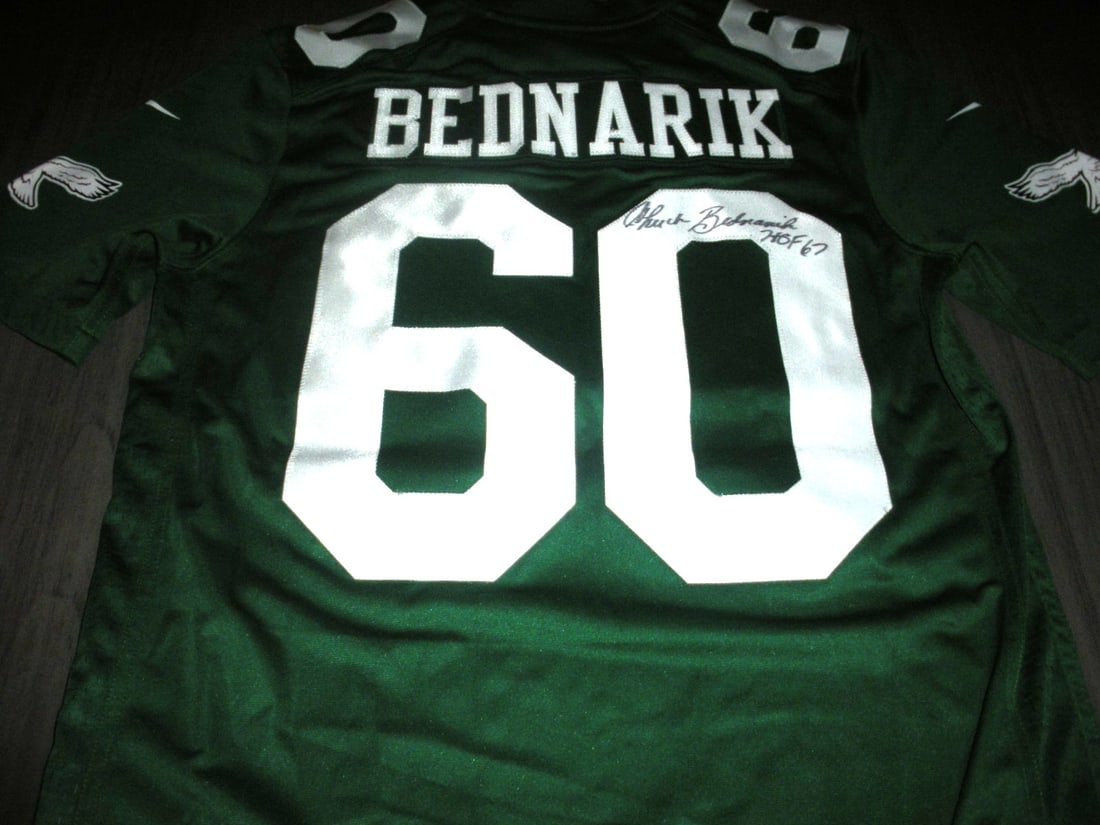 CHUCK BEDNARIK PHILADELPHIA EAGLES SIGNED NIKE JERSEY with COA: CHUCK BEDNARIK PHILADELPHIA EAGLES SIGNED NIKE JERSEY with COA This officially licensed Nike jersey is a unique collectible item, featuring the legendary Chuck Bednarik of the Philadelphia Eagles. It