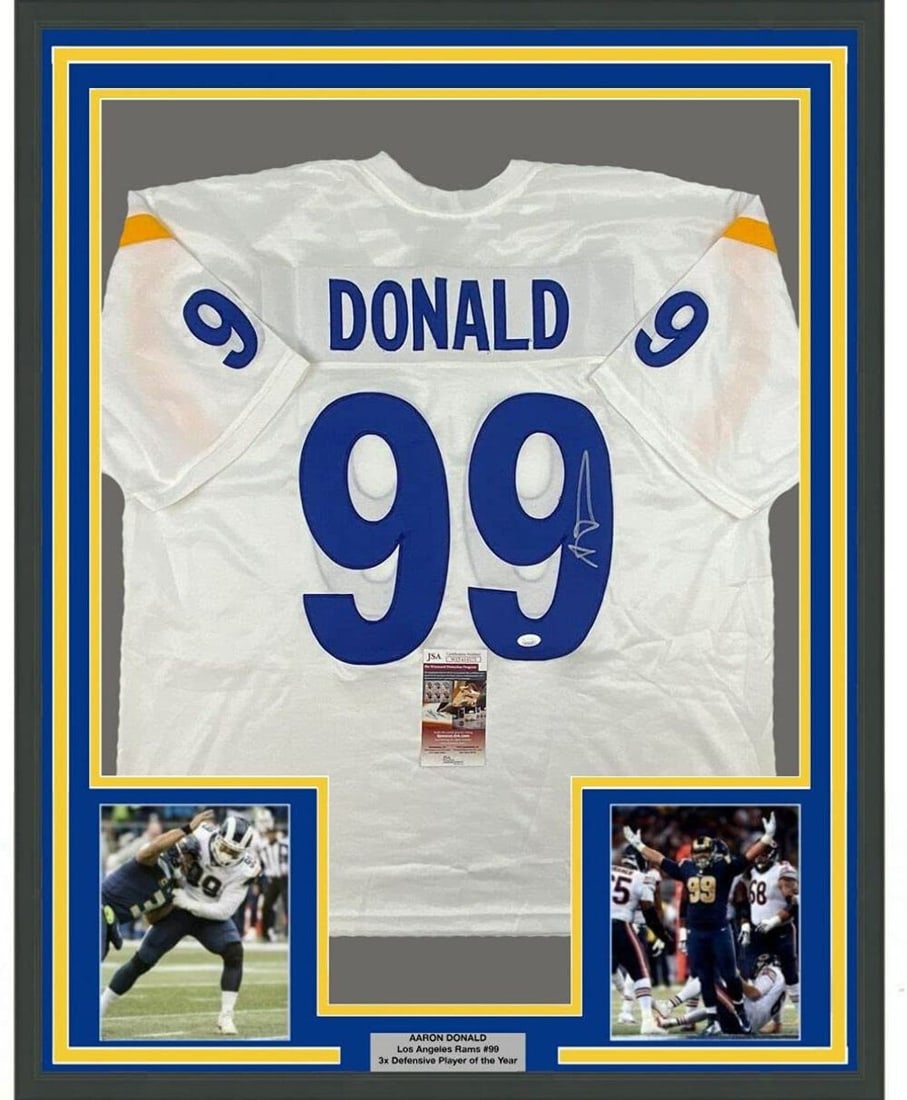 Framed Autographed Aaron Donald Los Angeles Rams Jersey with JSA COA: Framed Autographed Aaron Donald Los Angeles Rams Jersey with JSA COA This professionally framed and matted display features an autographed jersey of NFL star Aaron Donald from the Los Angeles Rams. Th