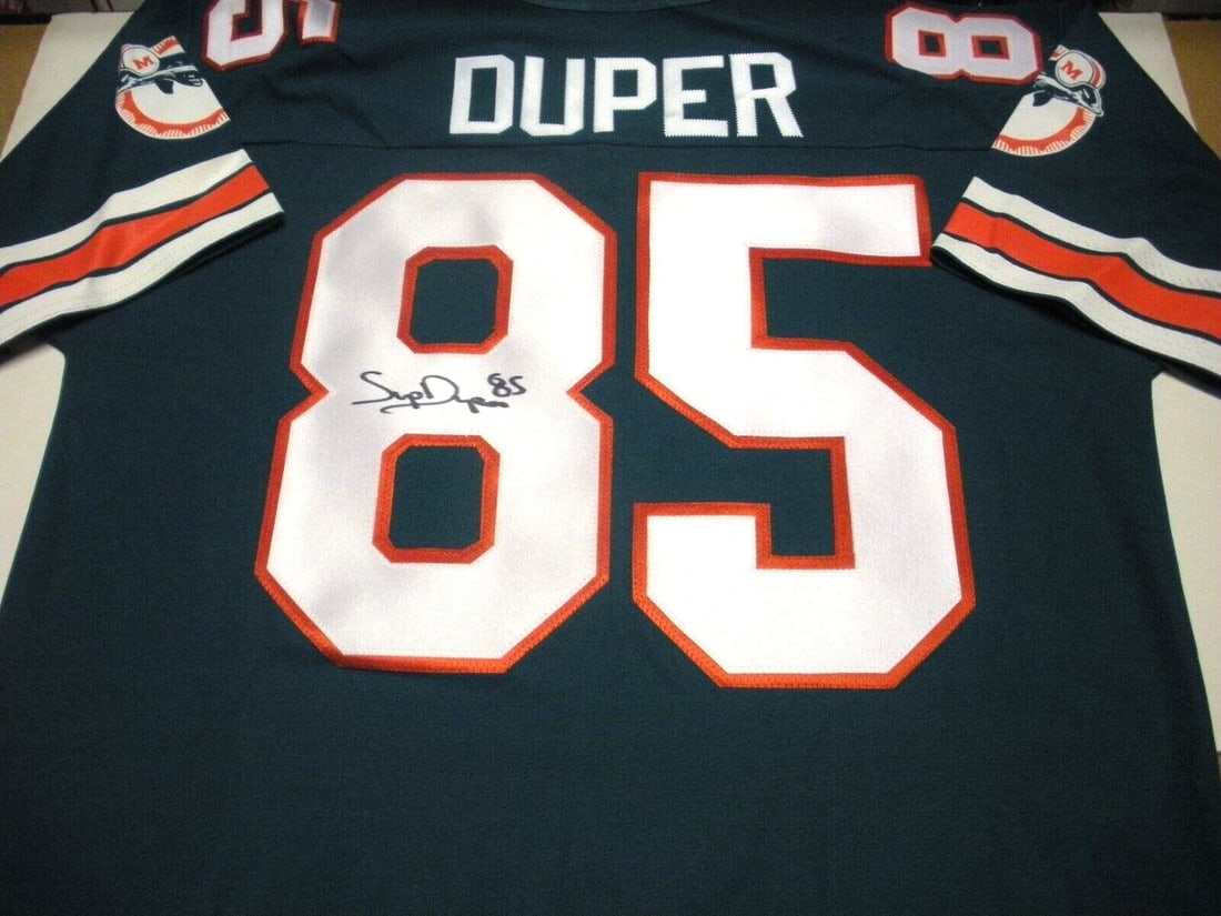 Mark Duper Miami Dolphins Signed Jersey with COA: Mark Duper Miami Dolphins Signed Jersey with COA This officially licensed Miami Dolphins athletic jersey features the signature of Mark Duper, a renowned NFL player. The jersey is an original piece an