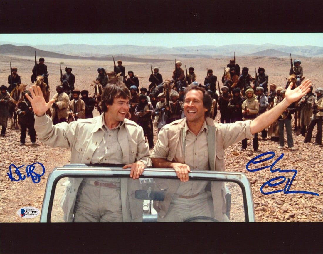 Autographed 11x14 Spies Like Us Jeep Photo Signed by Chase and Aykroyd BAS COA: Autographed 11x14 Spies Like Us Jeep Photo Signed by Chase and Aykroyd BAS COA This 11x14 photograph features a Jeep scene from the film "Spies Like Us" and has been personally signed by Chevy Chase a