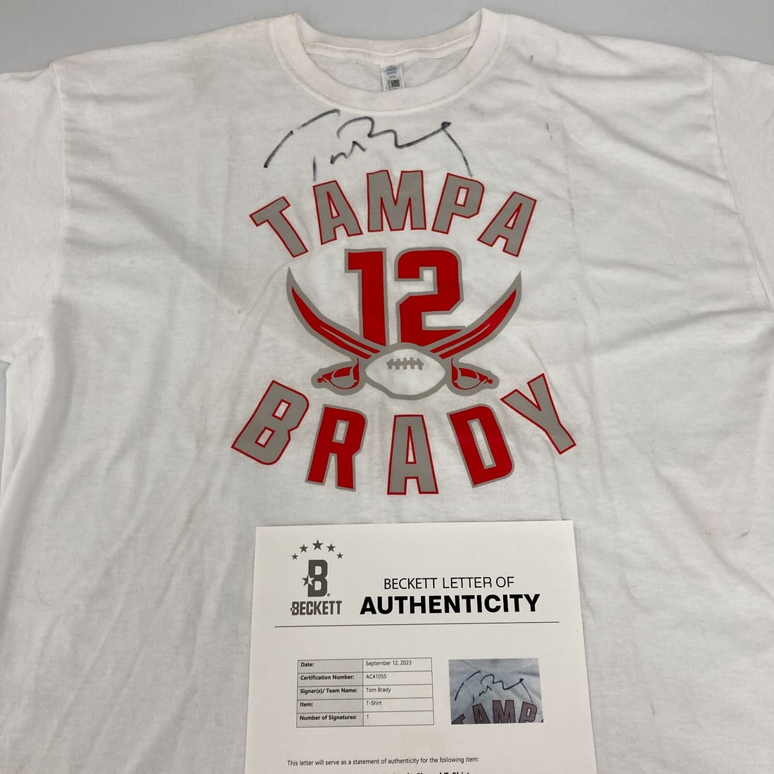Tom Brady Autographed Tampa Bay Buccaneers T-Shirt with Beckett COA: Tom Brady Autographed Tampa Bay Buccaneers T-Shirt with Beckett COA This authentic Tampa Bay Buccaneers t-shirt is signed by NFL superstar Tom Brady, showcasing a rare and personal connection to the p