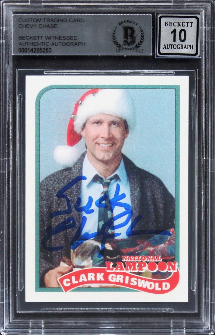 Chevy Chase Signed National Lampoon Trading Card Gem Mint 10 Suck Inscription: Chevy Chase Signed National Lampoon Trading Card Gem Mint 10 Suck Inscription This is a signed trading card featuring Chevy Chase from the iconic film National Lampoon's Christmas Vacation. The card i