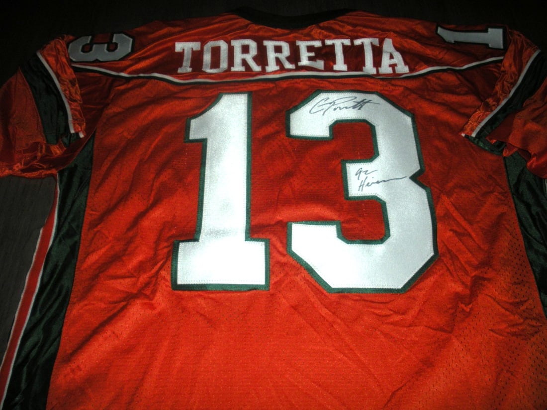 GINO TORRETTA SIGNED MIAMI HURRICANES NIKE JERSEY with COA: GINO TORRETTA SIGNED MIAMI HURRICANES NIKE JERSEY with COA This official licensed Nike jersey, signed by Gino Torretta, features the Miami Hurricanes logo and is a must-have for any football fan. This